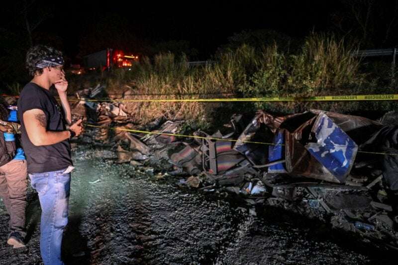 Un hombre observa el bus accidentado en Panamá, en el que murieron 40 migrantes.