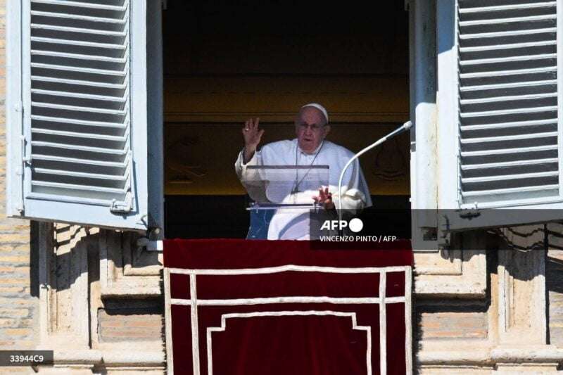 Pope Francis waves from the window of the apostolic palace during the weekly Angelus prayer on February 12, 2023 in The Vatican. (Photo by Vincenzo PINTO / AFP)