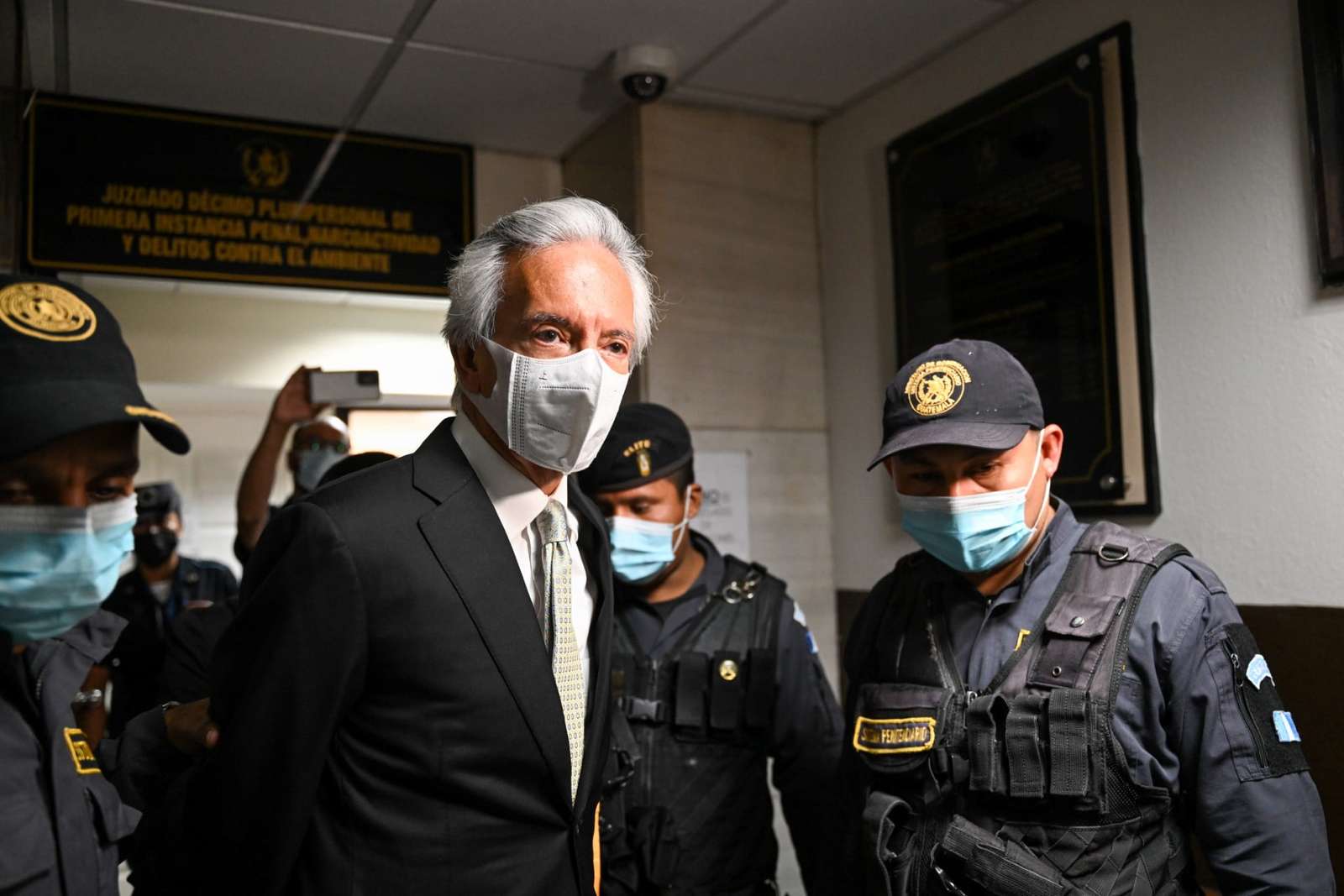 Guatemalan journalist Jose Ruben Zamora, President of the newspaper "El Periodico", is escorted by the police after a hearing in Guatemala City, on January 31, 2023. (Photo by Johan ORDONEZ / AFP)