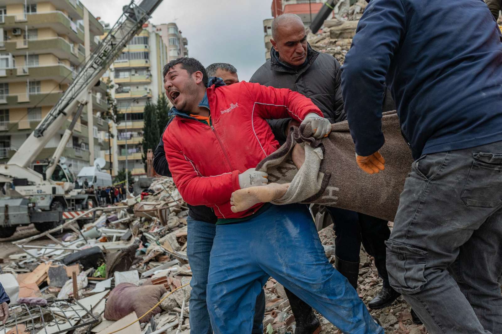 A rescuer reacts as he carries a body found in the rubble in Adana on February 6, 2023, after a 7.8-magnitude earthquake struck the country's south-east. - The combined death toll has risen to over 1,900 for Turkey and Syria after the region's strongest quake in nearly a century on February 6, 2023. Turkey's emergency services said at least 1,121 people died in the 7.8-magnitude earthquake, with another 783 confirmed fatalities in Syria, putting that toll at 1,904. (Photo by Can EROK / AFP)