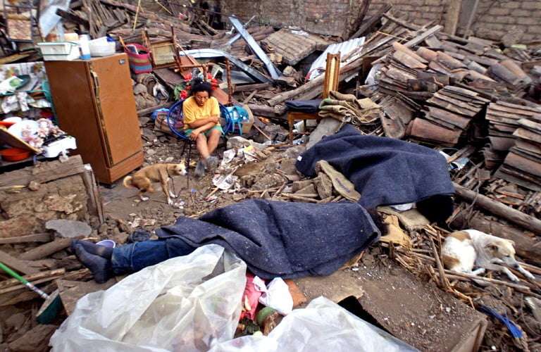 A woman sits among the shambles of her home 14 February 2001 in Verapaz, El Salvador one day after an earthquake shook the area 13 February. The official death toll rose to 274 with another 2,432 people injured, officials said. The earthquake measuring 6.1 degrees on the Richter scale struck, a month to the day after a 13 January quake in El Salvador killed more than 800 and left at least 2,000 missing and some 4,500 injured.  AFP PHOTO YURI CORTEZ (Photo by YURI CORTEZ / AFP)