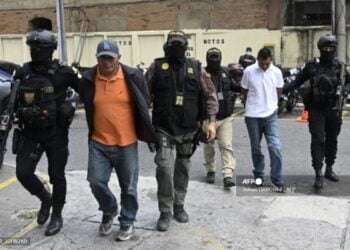 Miguel Felipe Francisco (2-L) and Felipe Diego Alonzo (2-R) are escorted by Police after being arrested, outside the Justice Palace in Guatemala City, on August 2, 2022. - Guatemalan authorities on Tuesday dismantled one of the "large" structures of illegal trafficking of people to the United States, after the capture of 19 people, four of them requested for extradition by that country, the Prosecutor's Office reported. (Photo by Johan ORDONEZ / AFP)