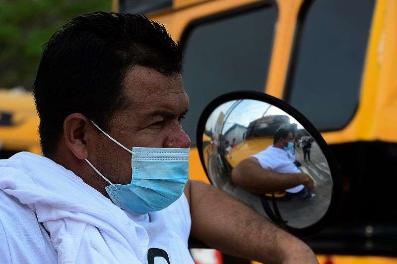 A bus driver stands during an indefinite strike of public transport -in seven of eighteen departments- asking the government of President Juan Orlando Hernandez for the readjustment of debts with banking institutions and demanding the vaccine against Covid-19, in the southern outskits of Tegucigalpa, on April 20, 2021. (Photo by Orlando SIERRA / AFP)