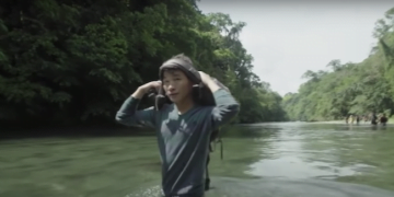 Un migrante chino cruza un río en la zona selvática del Tapón del Darién en Panamá.