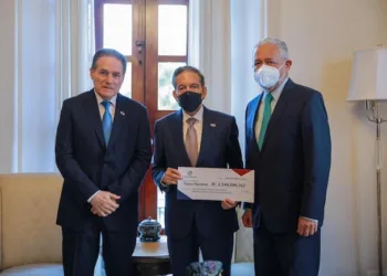 El presidente panameño Laurentino Cortizo (centro) recibe el cheque de la Autoridad del Canal de Panamá.