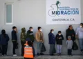 Migrantes guatemaltecos  deportados desde Estados Unidos, esperan en fila el miércoles 3 de enero en una base del aeropuerto de Guatemala. / AFP)