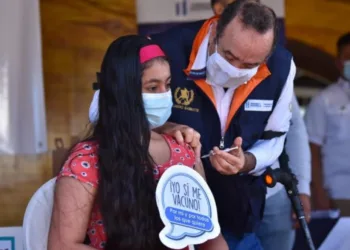 El expresidente Alejandro Giammattei, médico de profesión, vacuna contra el COVID-19, en noviembre de 2021, a una mujer.
