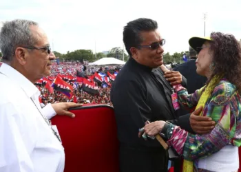 Los sacerdotes simpatizantes del régimen, Antonio Castro, izquierda, y Bismarck Carballo, centro, saludan a Rosario Murillo durante una celebración del 19 de julio en Managua.