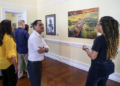 El ministro de Cultura de Belice, Francis Fonseca, escucha una explicación sobre las obras de arte.